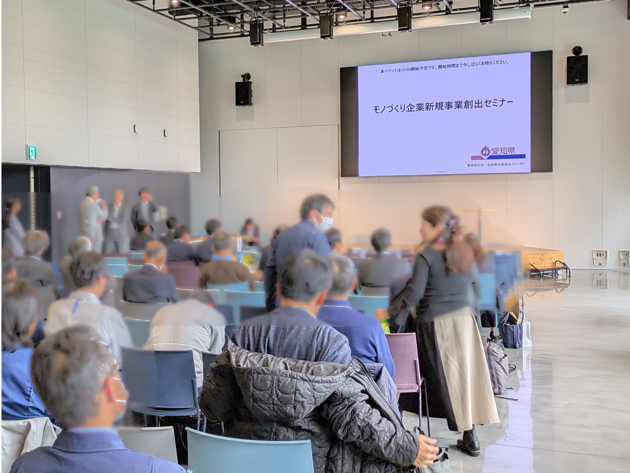 2026年3月18日にSTATION Aiで開催された「愛知県モノづくり企業新規事業創出セミナー」の会場風景。前方の大型スクリーンに「モノづくり企業新規事業創出セミナー」というタイトルが表示されており、多くの参加者が開始を待っている様子。